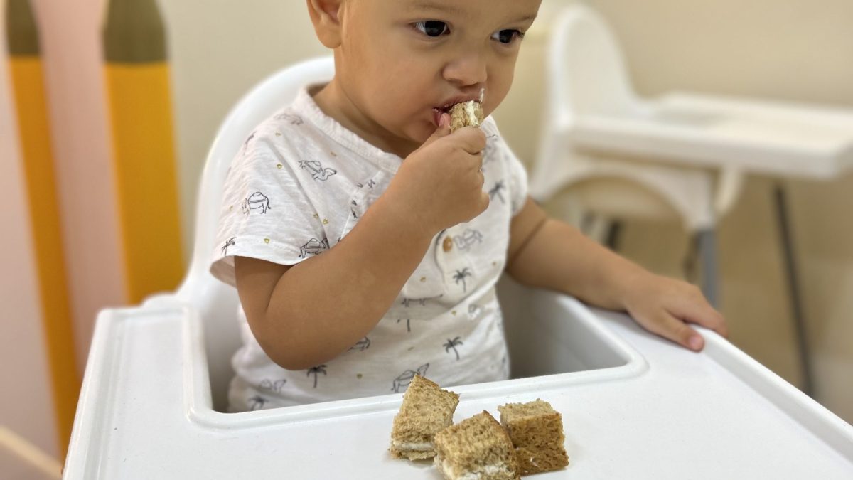 Toddler enjoying cake at Best Nursery in Mirdif