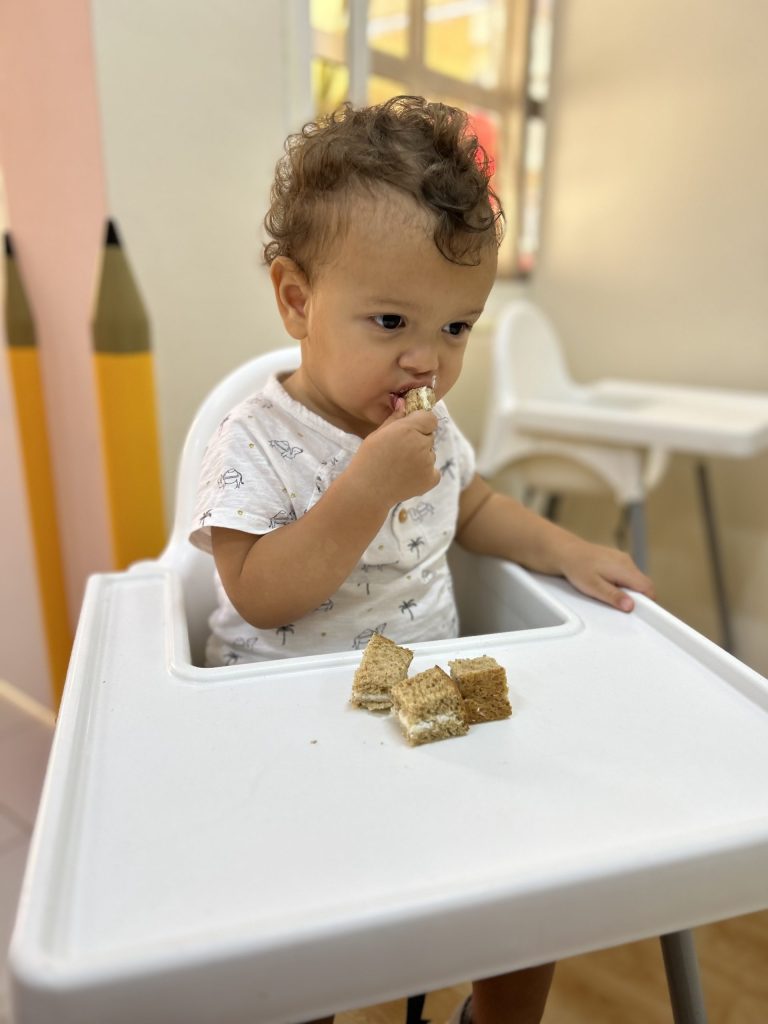 Toddler enjoying cake at Best Nursery in Mirdif