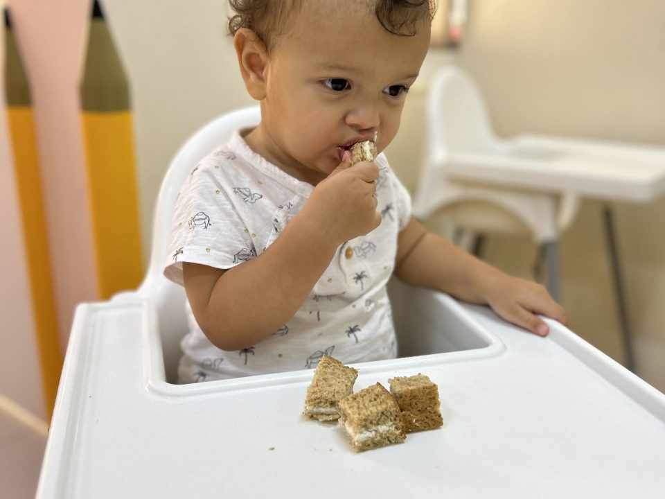 Toddler enjoying cake at Best Nursery in Mirdif