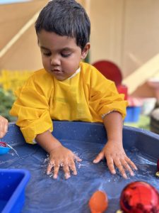 Young toddler playing in water at Nursery in International city