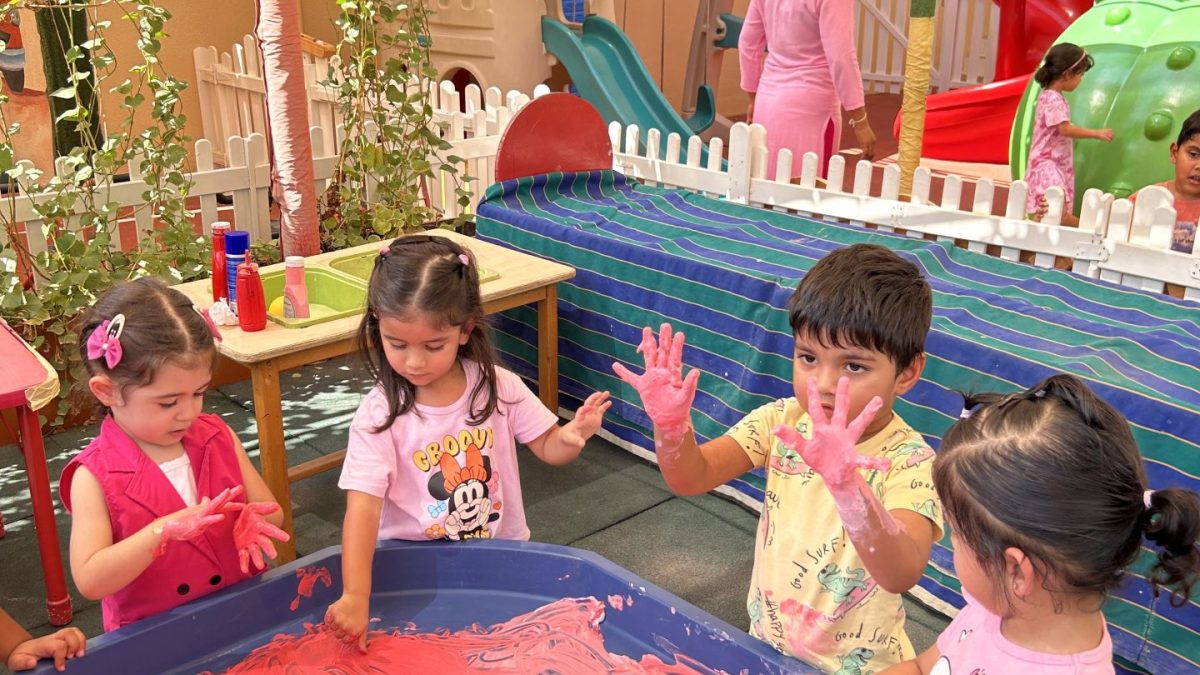 children playing with paint in nursery