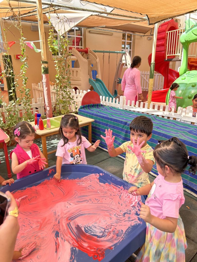 children playing with paint in nursery