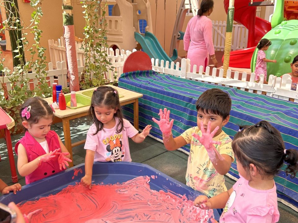 children playing with paint in nursery